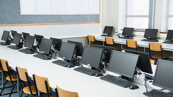 Laboratório de informática equipado com computadores para atividades educacionais, ilustrando a importância da infraestrutura tecnológica no acesso à educação digital e no desenvolvimento de competências dos estudantes.