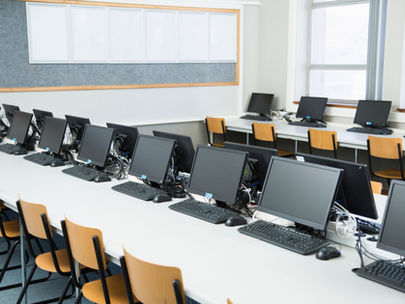 Laboratório de informática equipado com computadores para atividades educacionais, ilustrando a importância da infraestrutura tecnológica no acesso à educação digital e no desenvolvimento de competências dos estudantes.